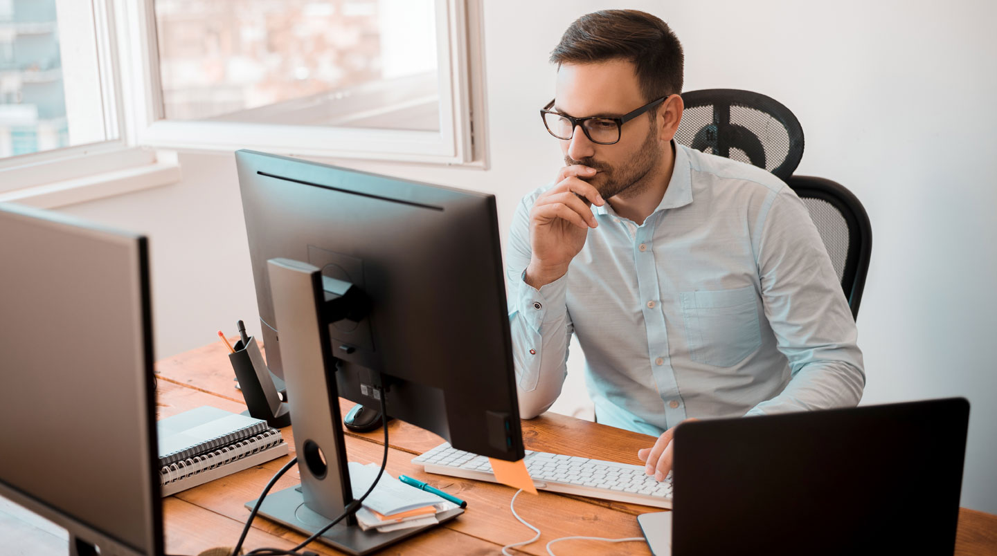 Poste de travail organisé combinant une bibliothèque murale fixe et un caisson mobile sur roulettes pour optimiser l'accès aux documents selon leur usage